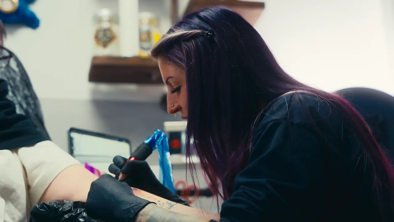 Nancy Mietziii arbeitet konzentriert an einem Tattoo