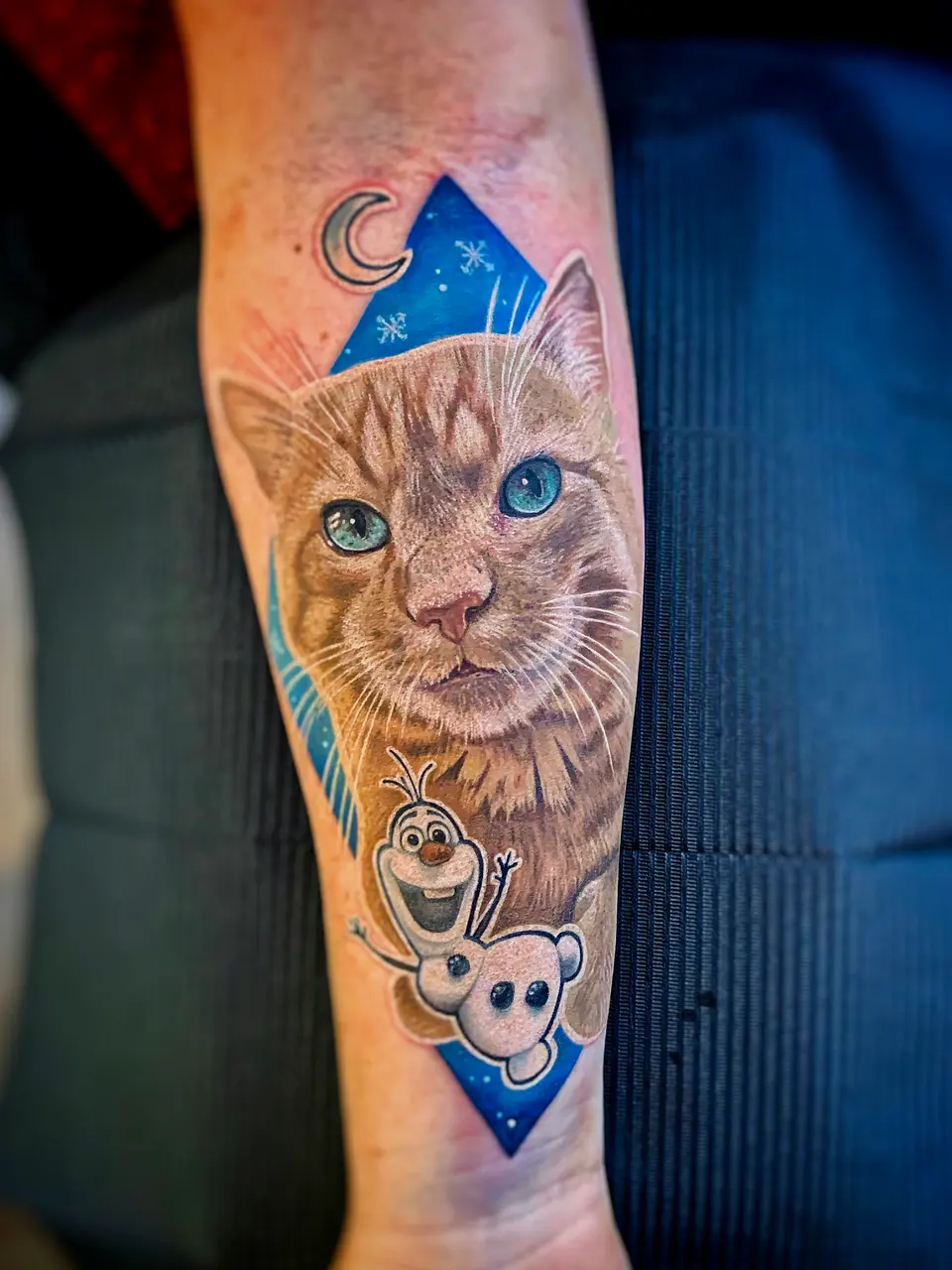 Rote Katze mit Schneemann Olaf als Unterarm-Tattoo