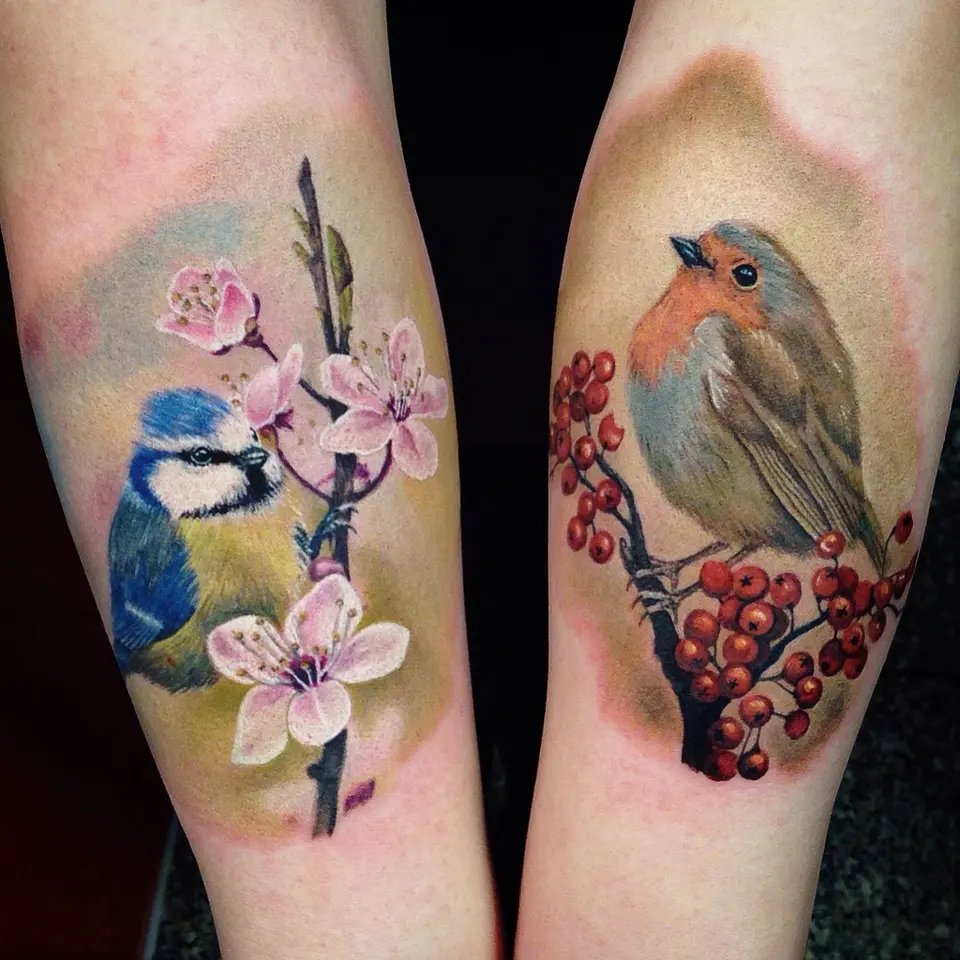 Zwei Vogel-Tattoos: Blaumeise mit Kirschblüten und Rotkehlchen mit Beeren